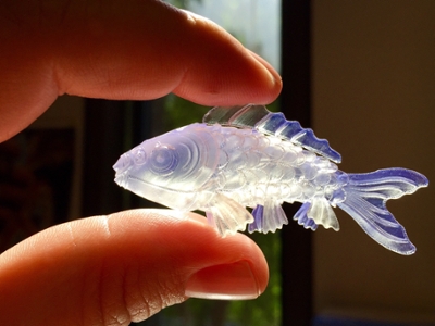 3d printed fish figurine held between two fingers